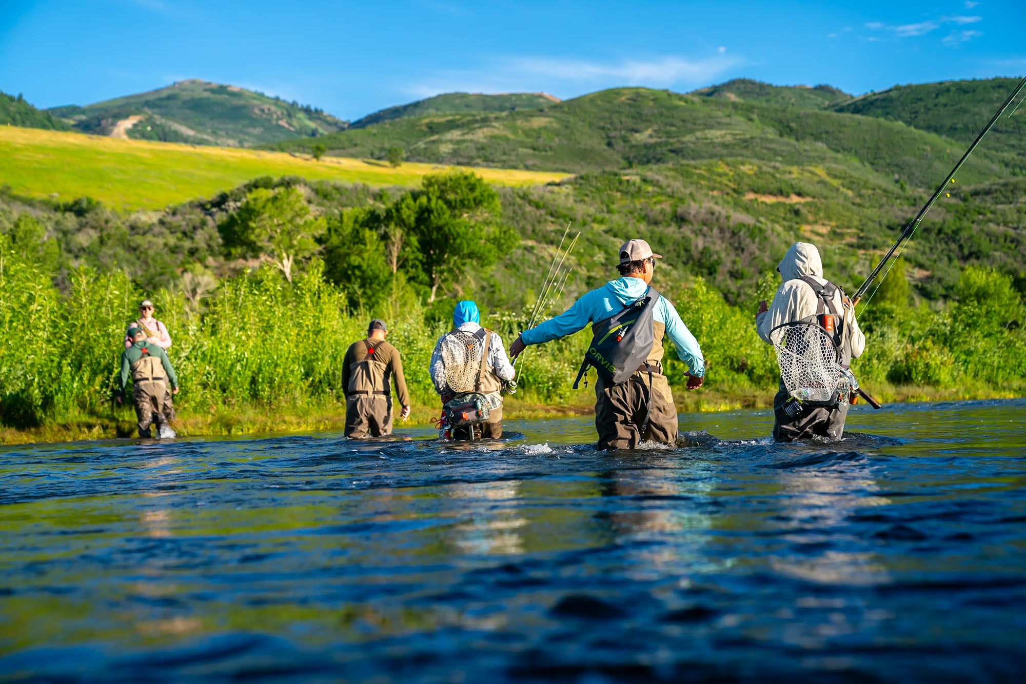 A group of anglers crossing Utah's Provo river to find a place to fish.