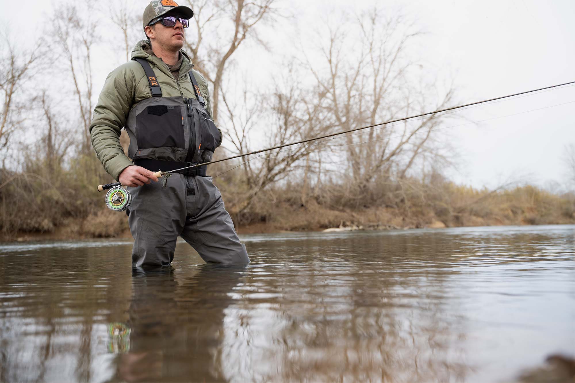 Man fishing in a river with the Grundens Vector series waders