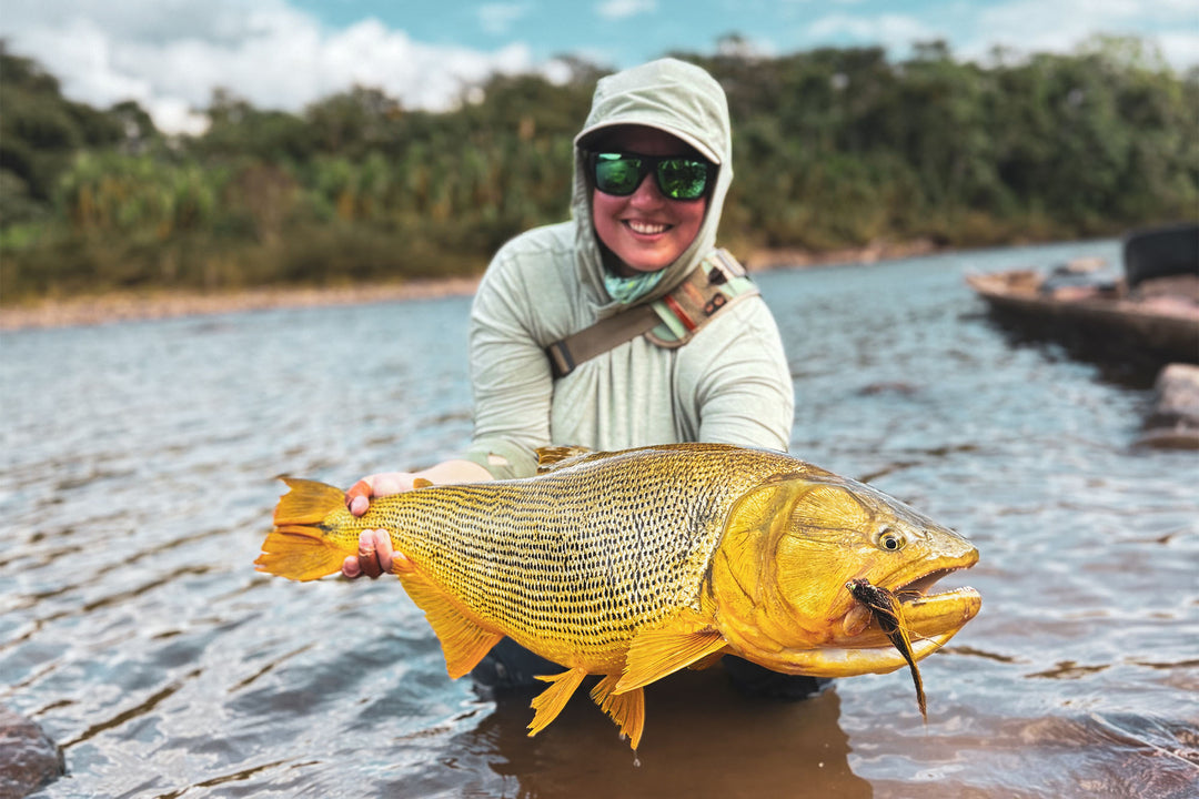 Fishwest Travel Guest Sarah showing off a giant Golden Dorado caught while fly fishing Bolivia's Pluma River.