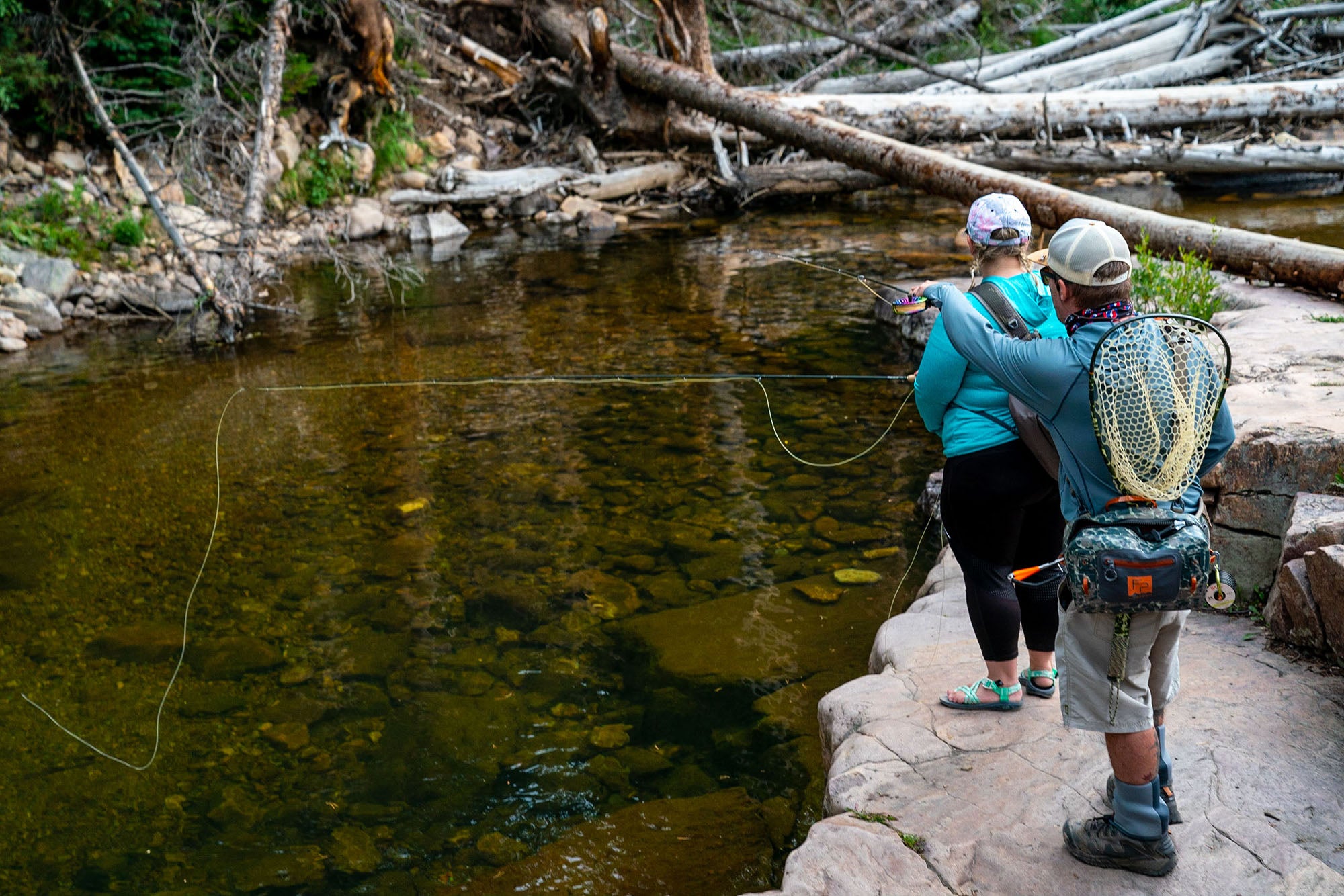 Two anglers fly fishing a small creek in Utah's Uinta National forest along the Mirror Lake Highway.